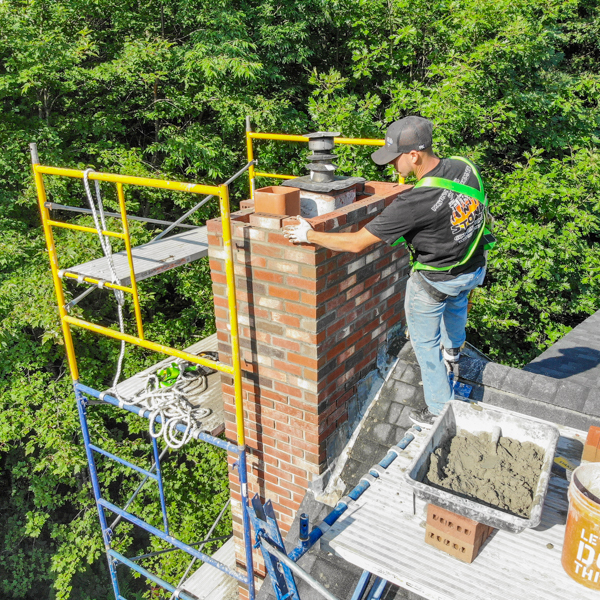 Chimney stack being rebuilt by mason